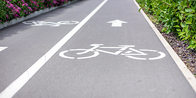 Ein Fahrradsymbol auf einem geteerten Weg.