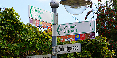 Ein Pfosten mit Schildern, die verschiedene Radwege anzeigen.
